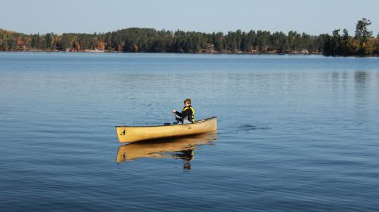 Boy solo-paddling a canoe on Lake Vermilion