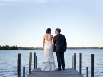 Bride and groom on a dock at Pehrson Lodge