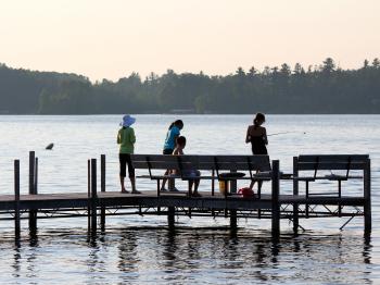 A family fishes from the dock at Pehrson Lodge