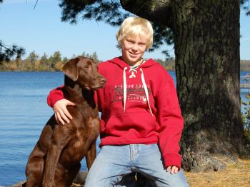 A boy and his dog in the yard of Aurora, pet-friendly cabin