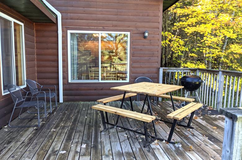 Deck area with picnic table, charcoal grill, and views of the lake.