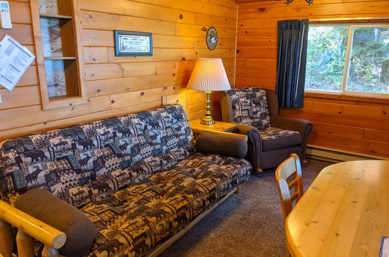 Living area with a futon, chair, and kitchen table.