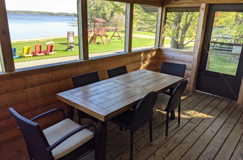 Screened porch area with seating and views of the beach.