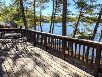 Deck area with picnic table, charcoal grill, and views of the lake.