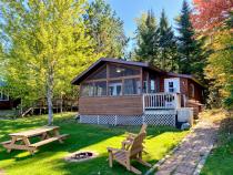 Exterior of Birches showing firepit, picnic table, and screen porch.
