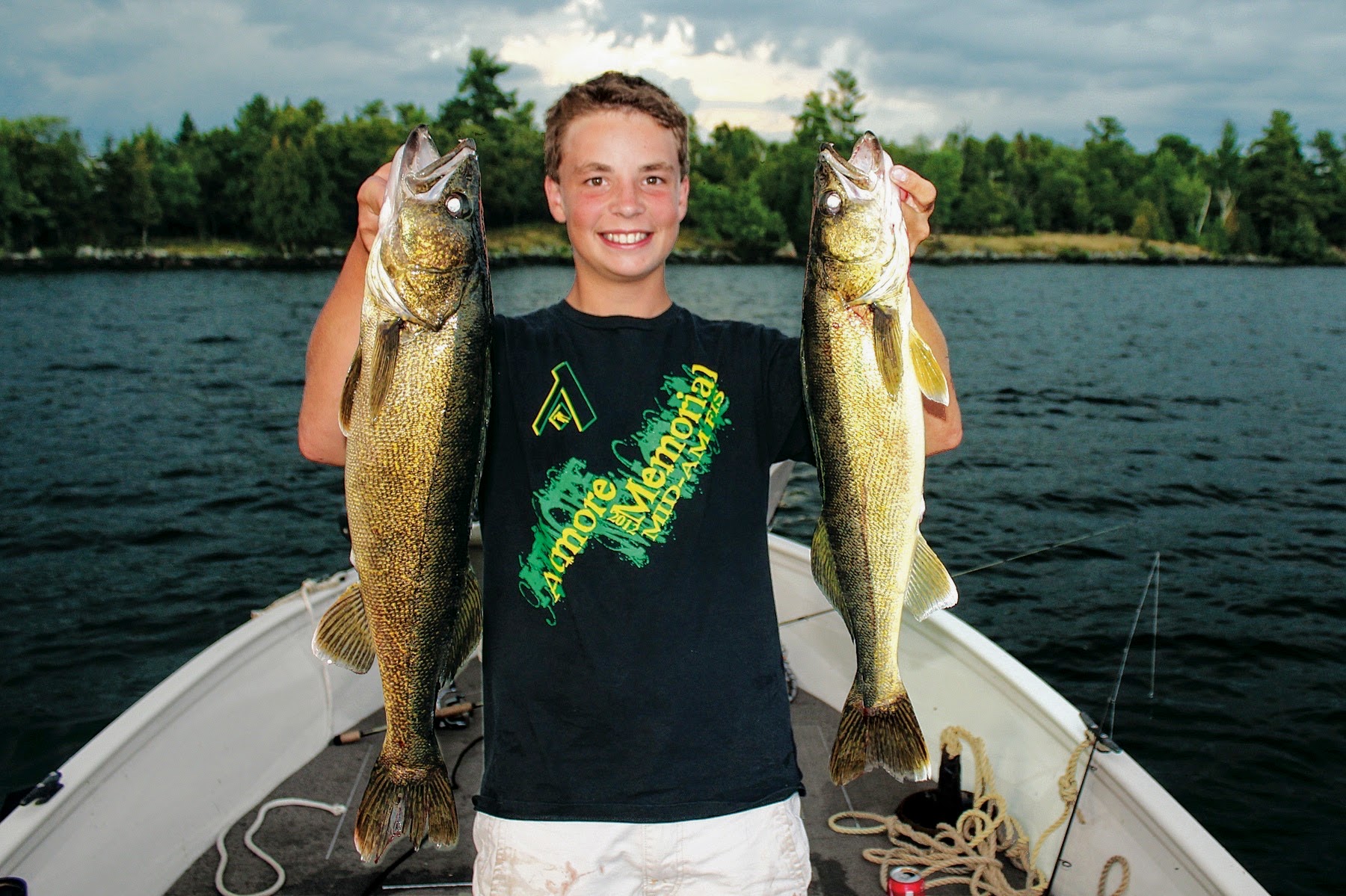 A boy proudly holds two walleye