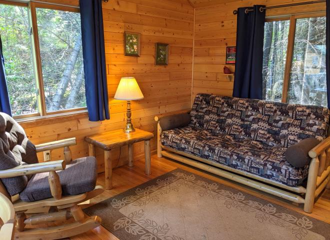 Small living area with a futon and rocking chair.