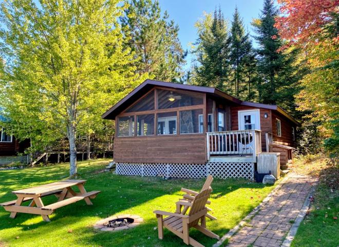Exterior of Birches showing firepit, picnic table, and screen porch.