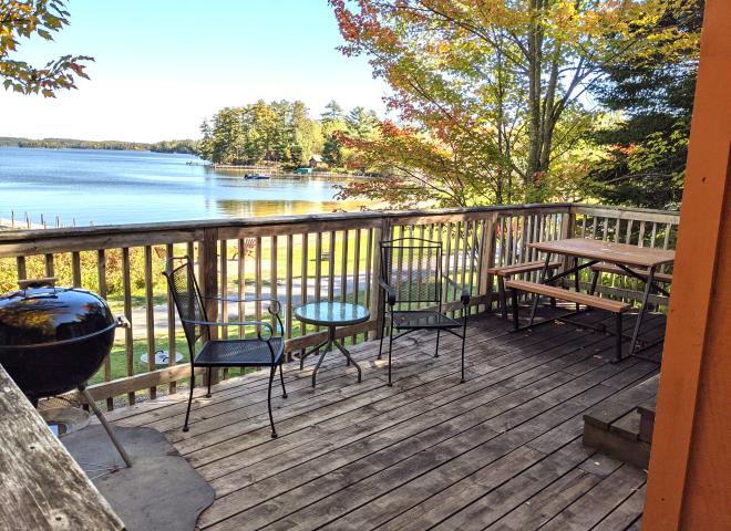 Deck area with a picnic table, charcoal grill, and overlooks the beach.