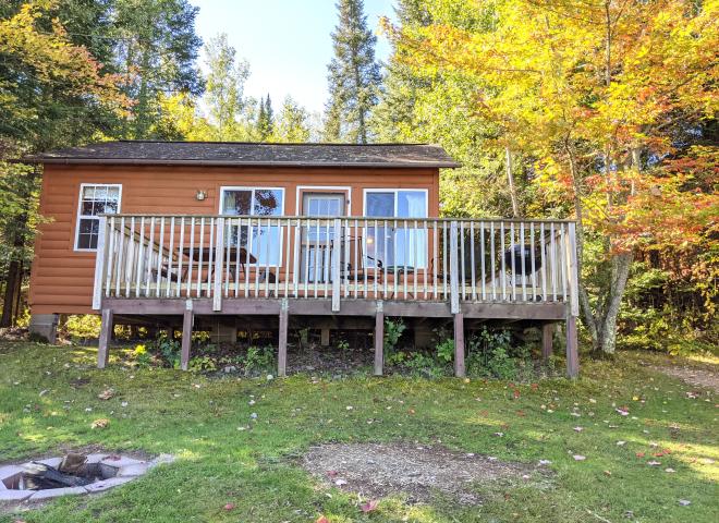 Lakeview cabin's exterior with driveway and firepit.