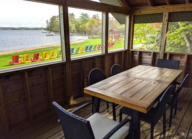 Screened porch area with seating and views of the beach.
