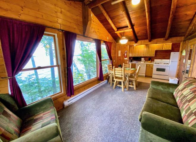 Lakeside facing living area with couch, chair, and kitchen table.