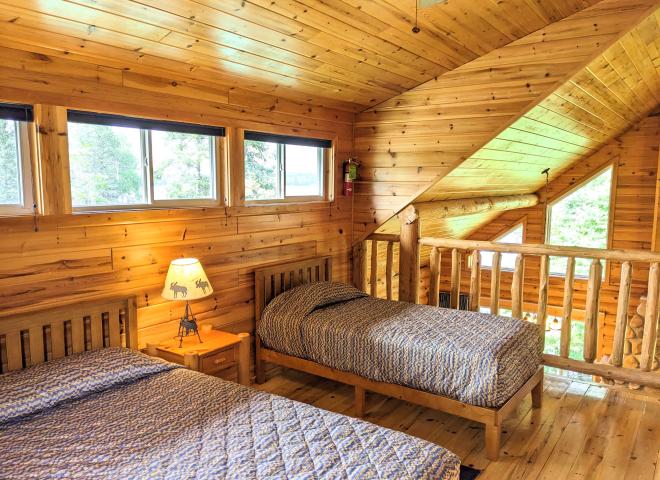 Loft bedroom with a queen and twin bed, as well as an ensuite bathroom.