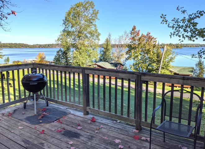 Deck area overlooking the lake with a charcoal grill.