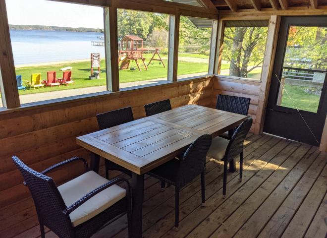 Screened porch area with seating and views of the beach.