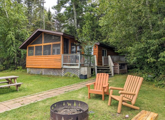 Lincoln cabin showing firepit, picnic table, and screened porch.