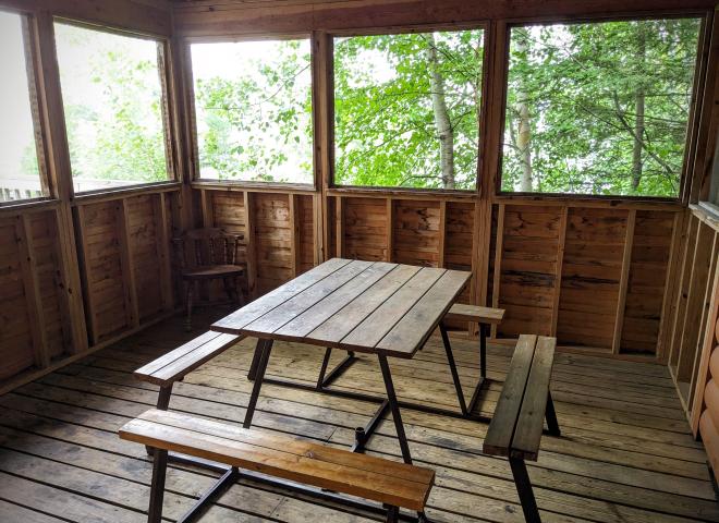 Screen porch with a picnic table.