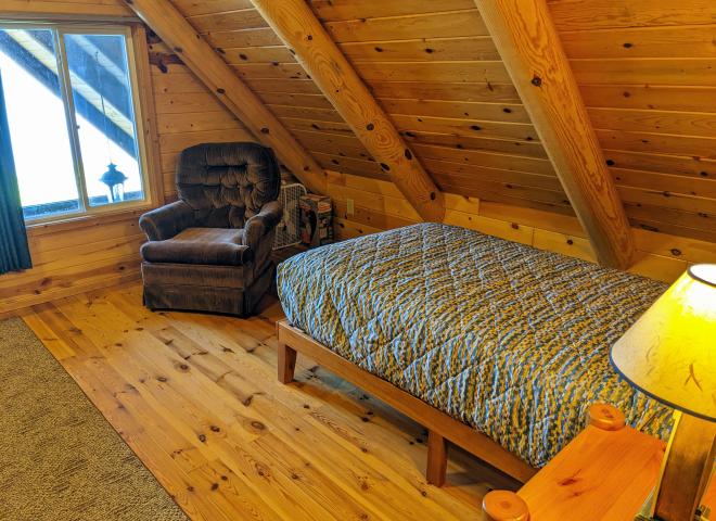 Loft bedroom with a twin and chair.
