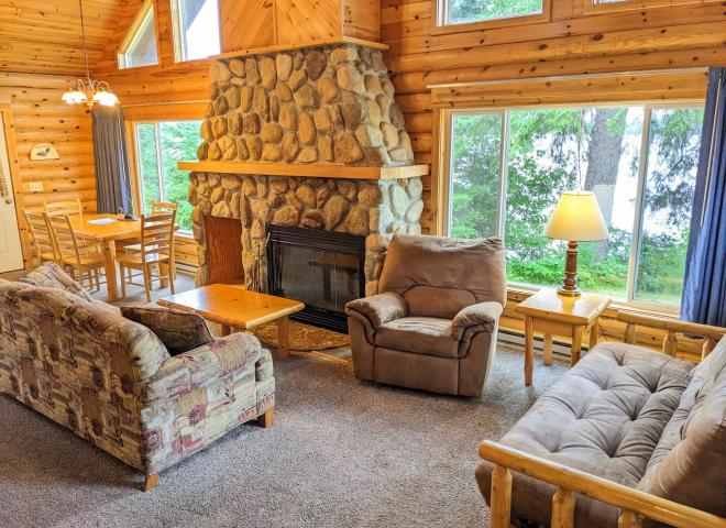 Living area with couch, recliner, futon, and wood burning fireplace.