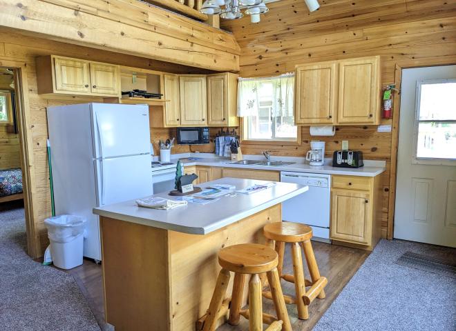 Kitchen with refrigerator, stove, dishwasher, and island seating.