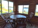 Screened porch with seating and views of the beach and Lake Vermilion.