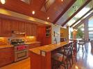 Open concept kitchen with granite countertops, island and bar height table.