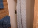 Bathroom one with a small stall shower.