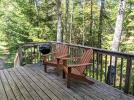 Deck area with seating and charcoal grill.