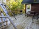 Deck area with a picnic table, swing, charcoal grill, and views of Lake Vermilion.