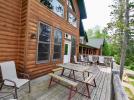 Deck area off the living room with picnic table and deck chairs.