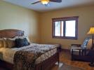 Lower level ensuite bedroom with lake view, queen bed, and twin futon.