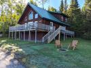 Exterior of the spacious, 2 level Sandpiper cabin with a large deck and firepit seating.