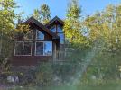 Exterior of Wren - two story cabin with two story windows and views, and a large deck.