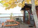 Sea Spray's deck with picnic table, grill and a tree touched with fall colors.