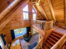 Upstairs loft with a queen bed and exit to a small, second level seating area.