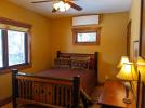 Second main floor bedroom with vanity sink and queen bed.