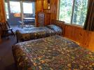 Main floor bedroom one with a queen & twin bed, and patio doors to the screened porch.