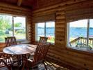Screen porch with round table and views of Lake Vermilion.