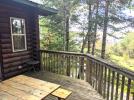 Deck area with a picnic table, trees for shade and views of the lake.