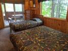 Main floor bedroom with a queen and twin bed, as well as patio doors to the screened porch.