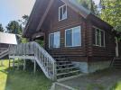 A frame cabin with a 3 season porch and deck area.