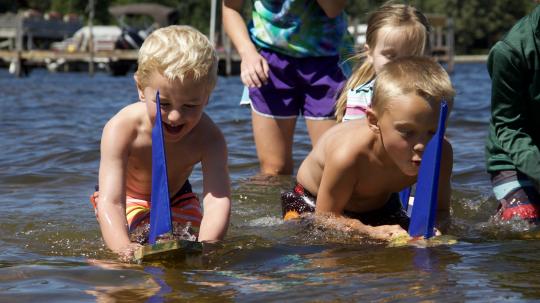 Children playing with model sailboats