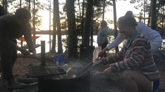 Family roasts marshmallows outdoors at a cookout on Lake Vermilion