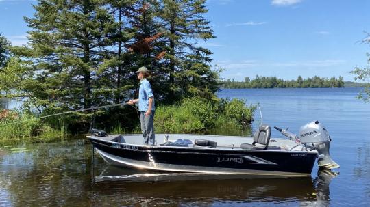 Fisherman casting from Lund Fury rental boat