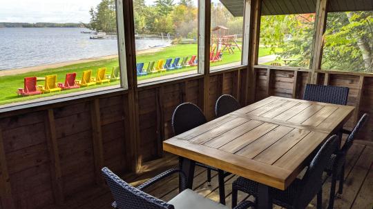 Screened porch with seating and views of the beach and Lake Vermilion.