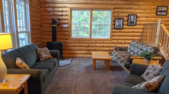 Spacious living room with ample seating, futon, and gas burning fireplace.