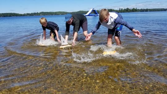 A family competes against each other in a Regatta with their handmade sailboats.