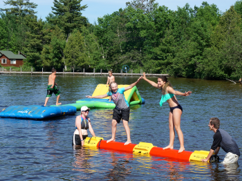 Guests play on the shallow water toys at the beach