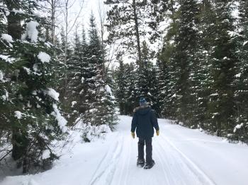 Man snowshoes on Pehrson Lodge on-site hiking trails