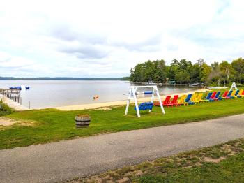 Sand beach with loungers, swinging chair, and water inflatables.